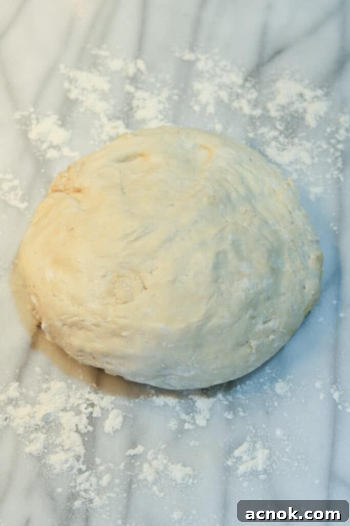 risen pizza dough turned onto a floured surface