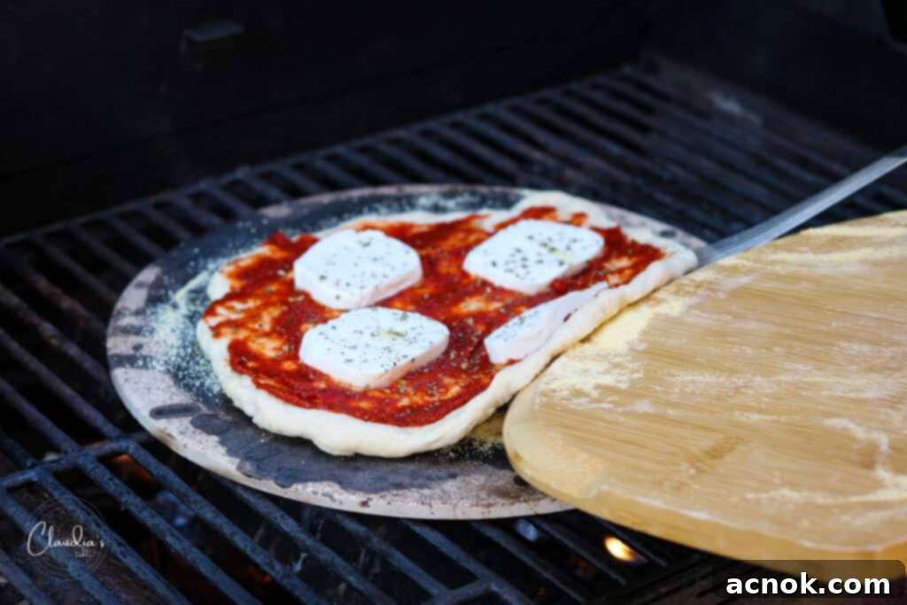 pizza being fully slid onto a pizza stone for baking