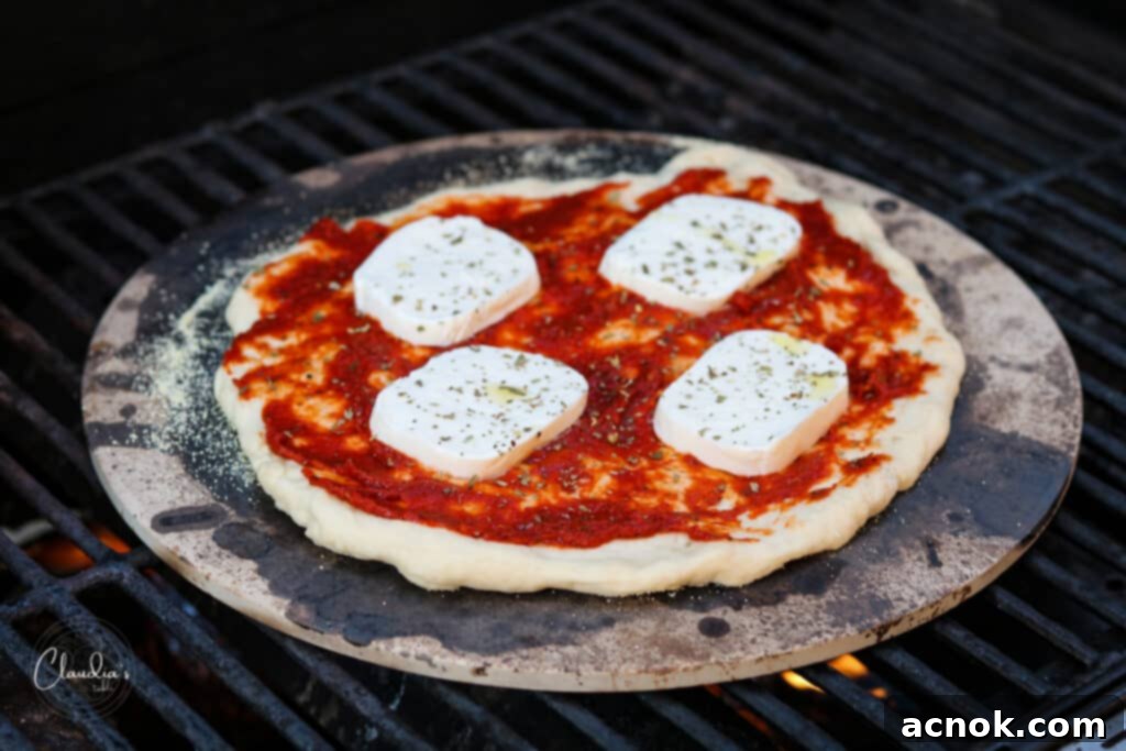 pizza cooking on a pizza stone on a grill