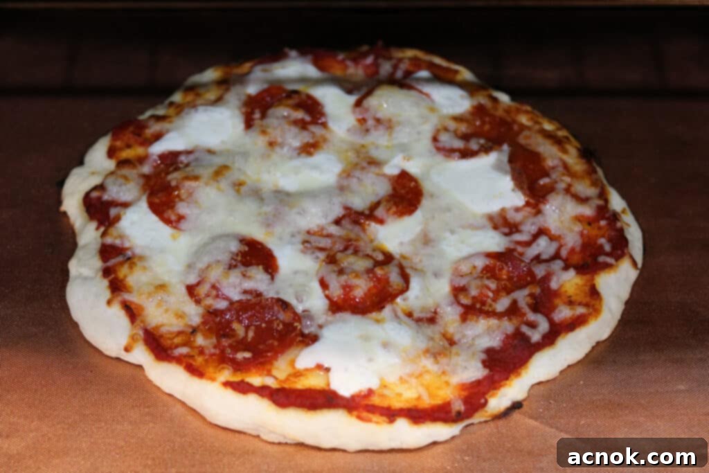 pizza baking in the oven with a copper mat, showing a golden crust