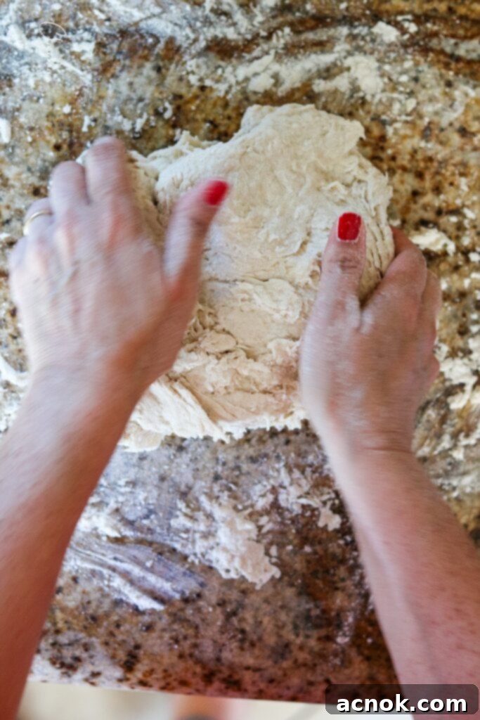 hands kneading pizza dough until smooth and elastic