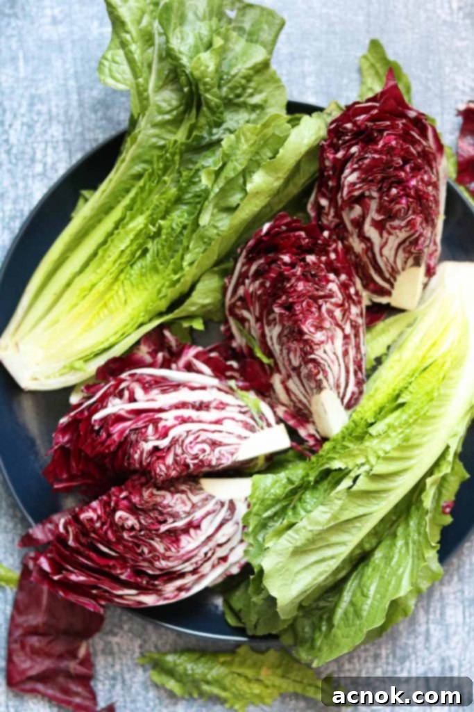 Smoky Grilled Romaine Radicchio Caesar 3 Fresh Romaine lettuce halves and radicchio quarters neatly arranged on a plate, visibly brushed with olive oil and seasoned with salt and pepper, ready for grilling