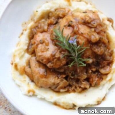 Chicken in Shallot Fig Butter Sauce plated with mashed potatoes and fresh herbs, ready for serving.