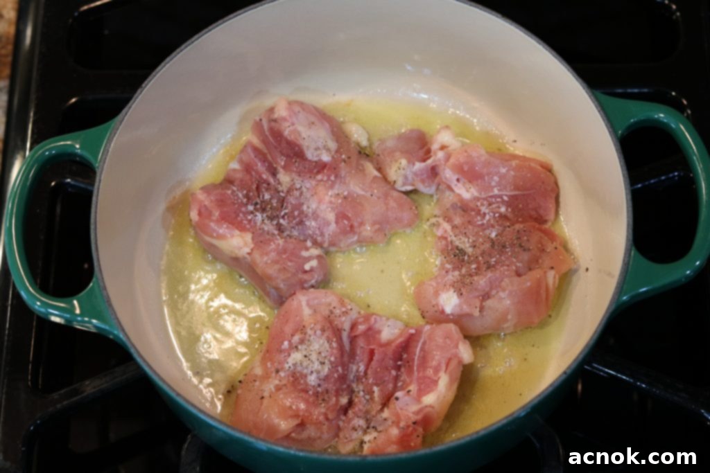 Raw chicken in a pan, ready for browning.