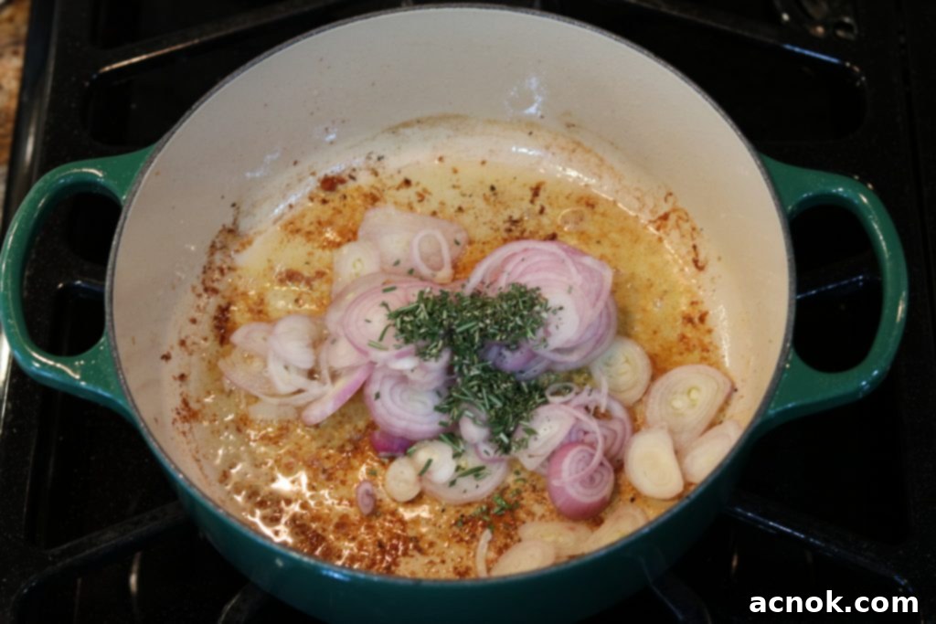 Sautéing shallots and rosemary in the pan after removing chicken.