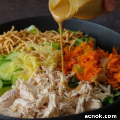 creamy sesame dressing poured onto classic Chinese Chicken Salad