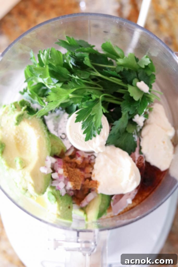 Step 1: All ingredients for the avocado dressing placed in a food processor bowl.