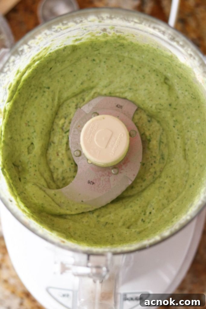 Step 2: Food processor actively blending the avocado dressing ingredients for a smooth consistency.