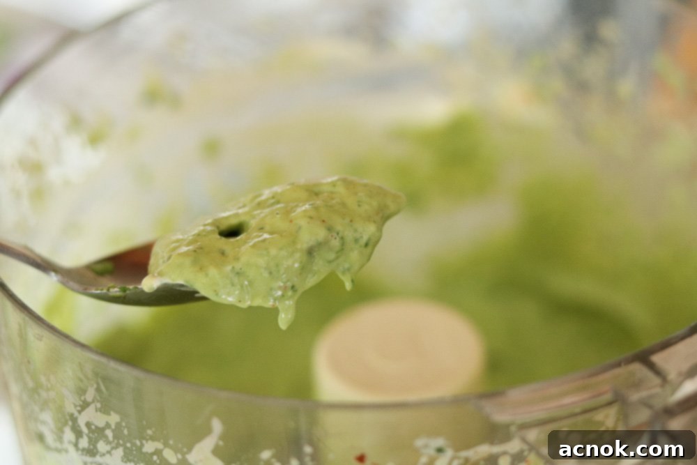 Step 3: A spoon sampling the finished avocado dressing, ready for final seasoning adjustments.