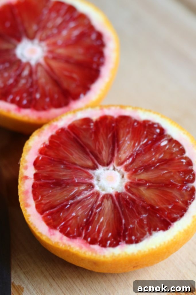 Close-up of a vibrant blood orange, sliced in half to showcase its distinctive ruby-red, juicy flesh and segments.