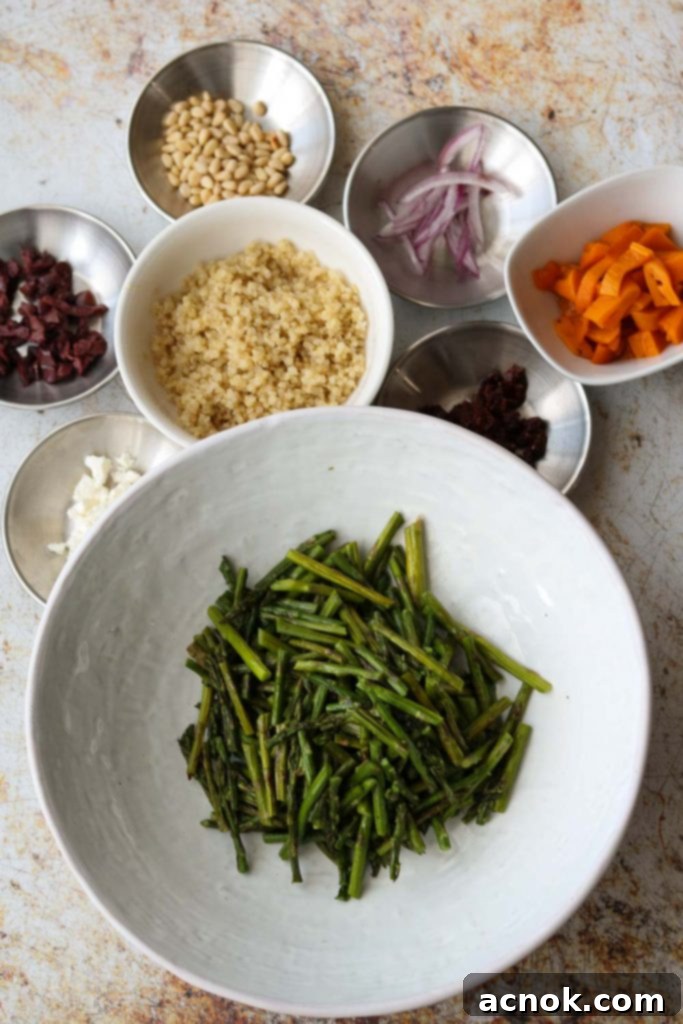 selection of fresh and jarred ingredients for warm quinoa salad including roasted peppers, olives, feta, and sun-dried tomatoes