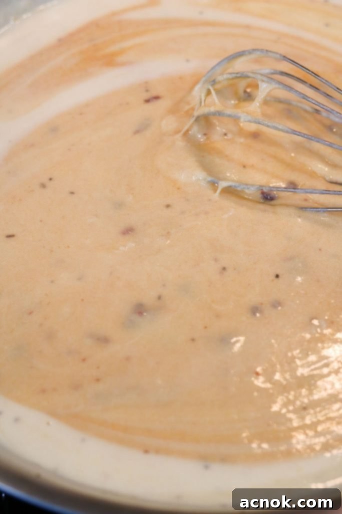 Chipotle cheese sauce being stirred until fully combined and smooth