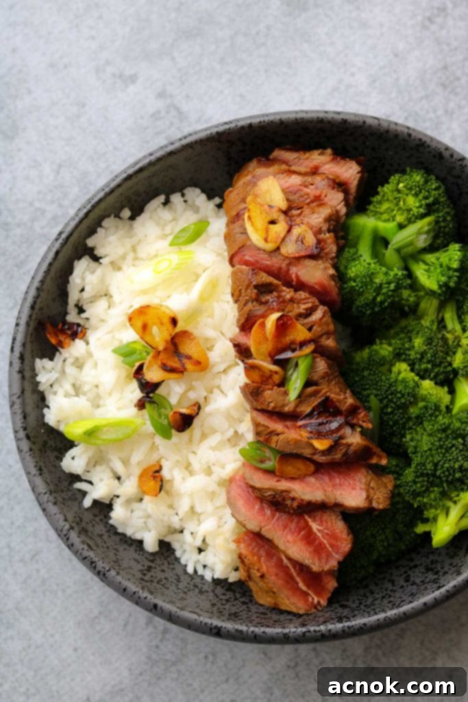 lemon soy flat iron steak with crispy garlic in bowl with rice and broccoli