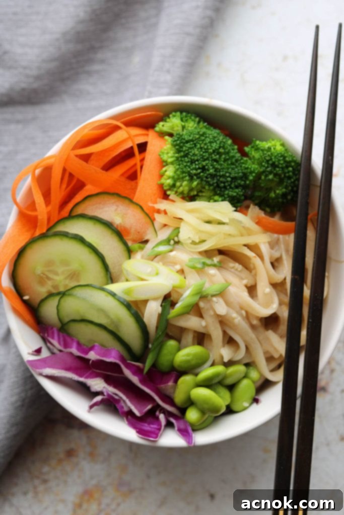 creamy sesame rice noodles in bowl with chopsticks