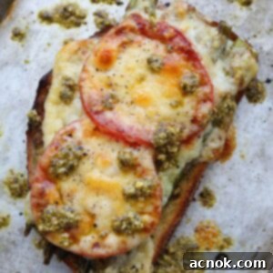 Final plated Roasted Asparagus Tomato Pesto Melt with a fork, ready to eat