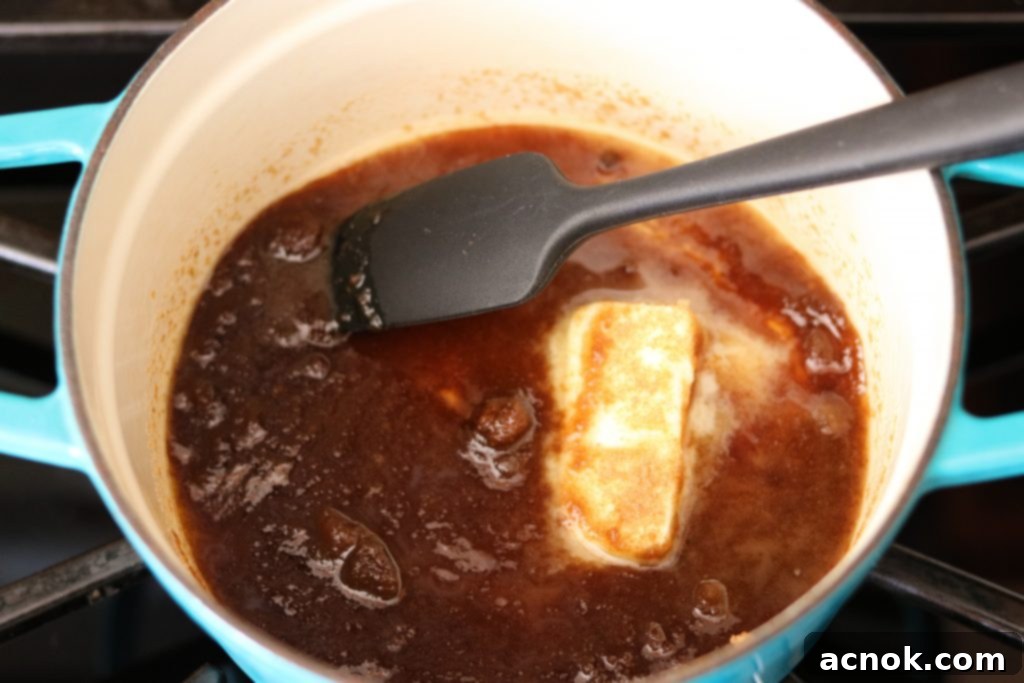 Brown sugar and unsalted butter melting together in a small, heavy-bottomed saucepan on the stovetop.