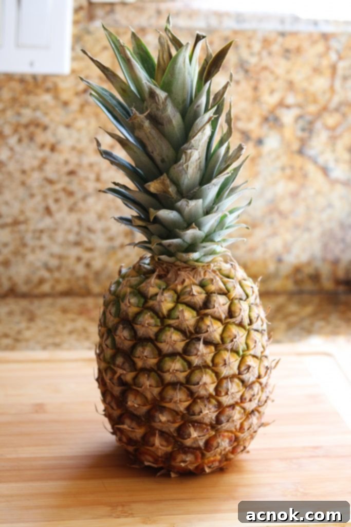 Fresh pineapple on a wooden cutting board, ready for peeling