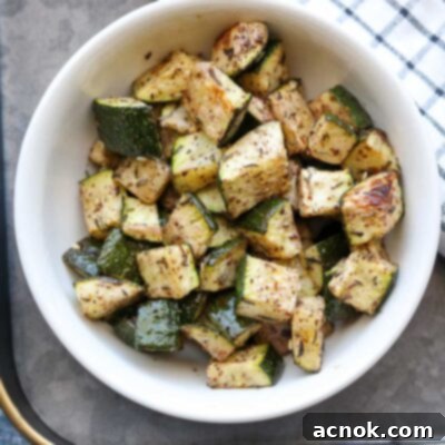 A serving of oven roasted Za'atar zucchini on a plate, with a napkin on the side
