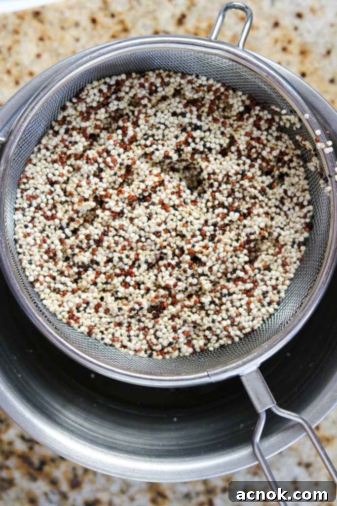 Rinsing quinoa thoroughly in a fine-mesh strainer under cold water until clear