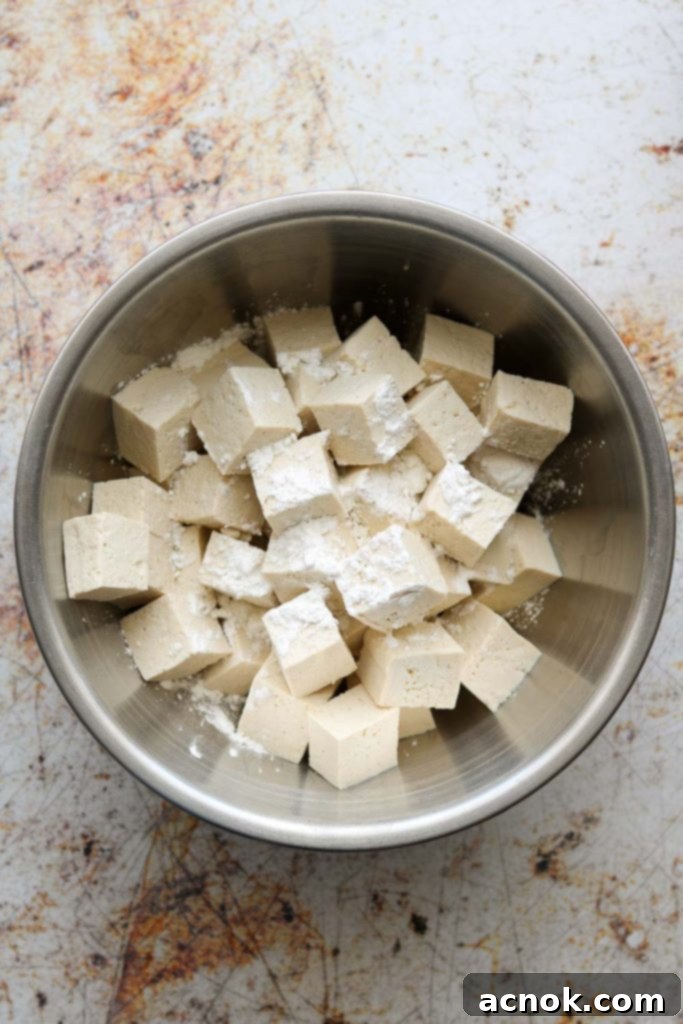 Tofu being tossed with cornstarch
