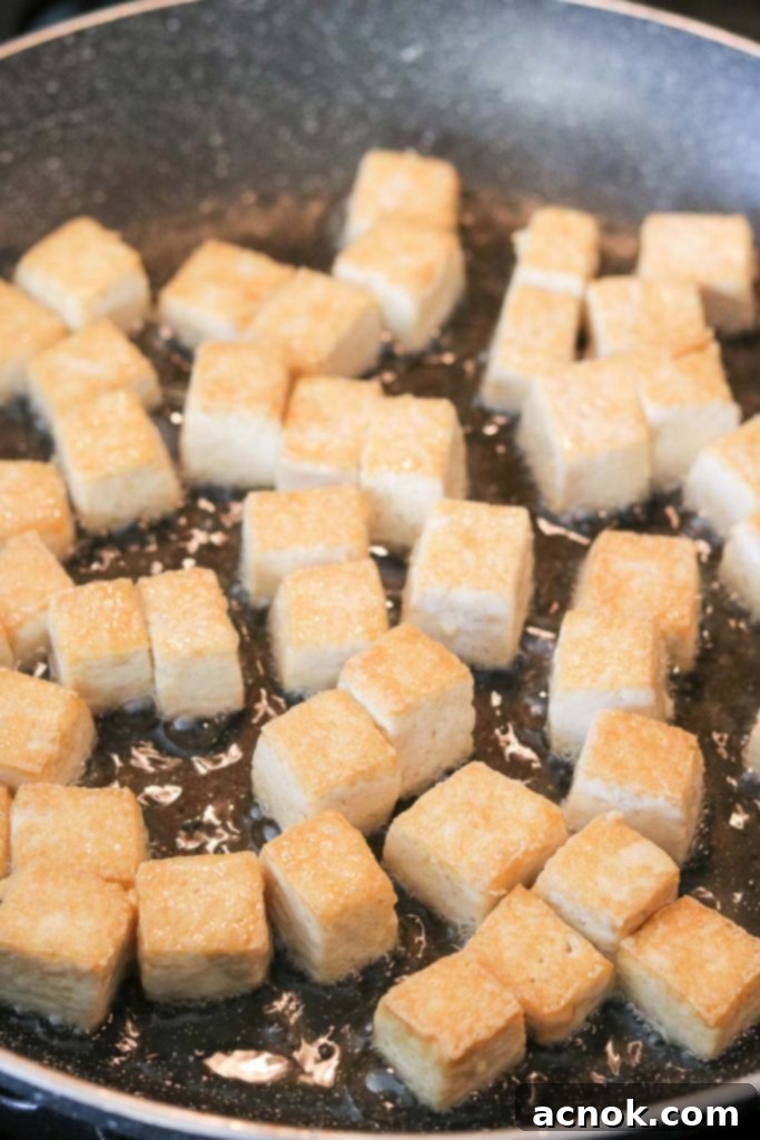 Frying tofu cubes in a pan