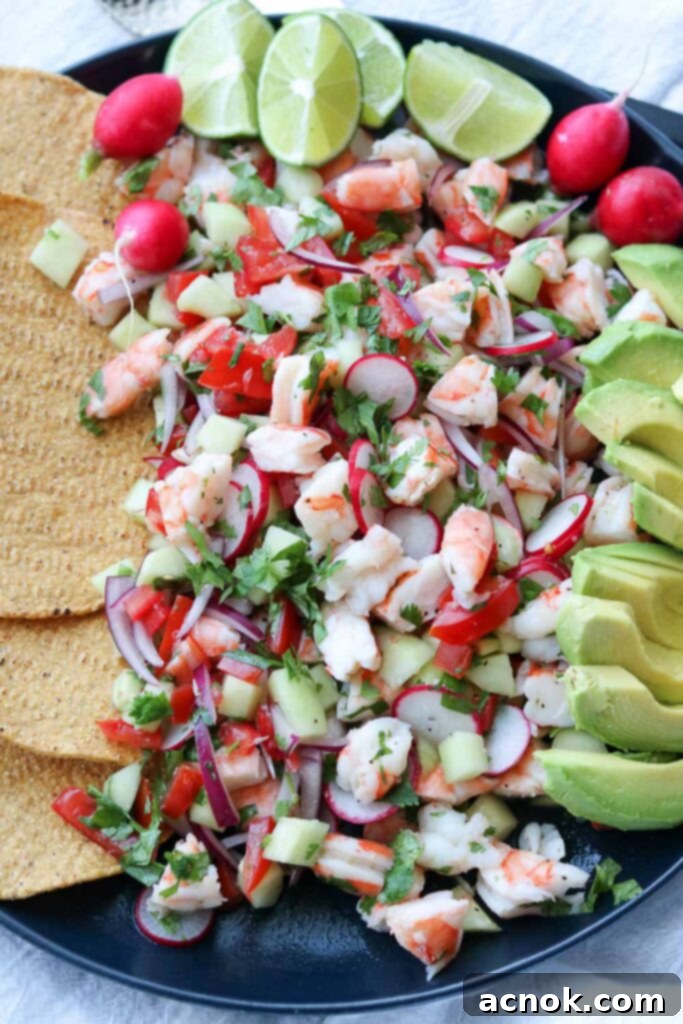 Vibrant shrimp ceviche in a large platter, garnished with fresh avocado slices and served alongside crispy tostadas, ready to be enjoyed.