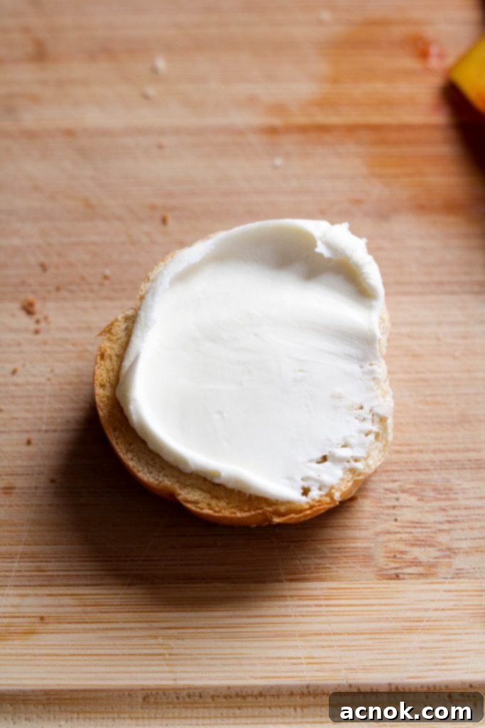 Mascarpone cheese being spread on a crostini base