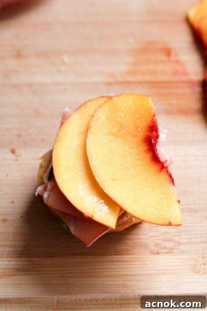 Thinly sliced peaches on crostini with prosciutto, basil, and mascarpone