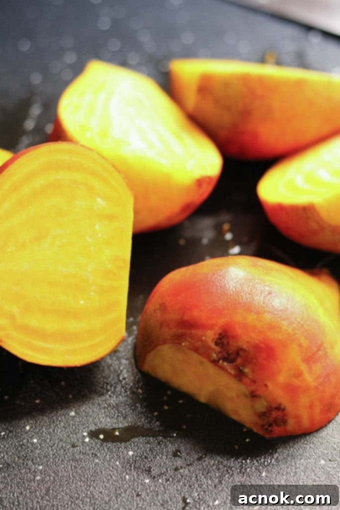 Step 2: Slice the scrubbed golden beets evenly in halves, preparing them for roasting.