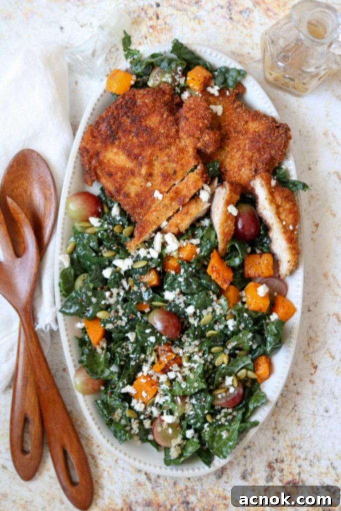 Crispy Chicken Schnitzel and Autumn Kale Salad served on a large platter with serving utensils, perfect for a fall dinner.