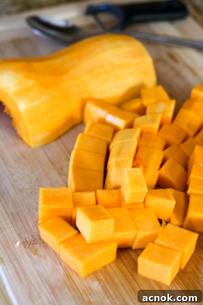 Slicing a butternut squash in half and cubing it for the salad.