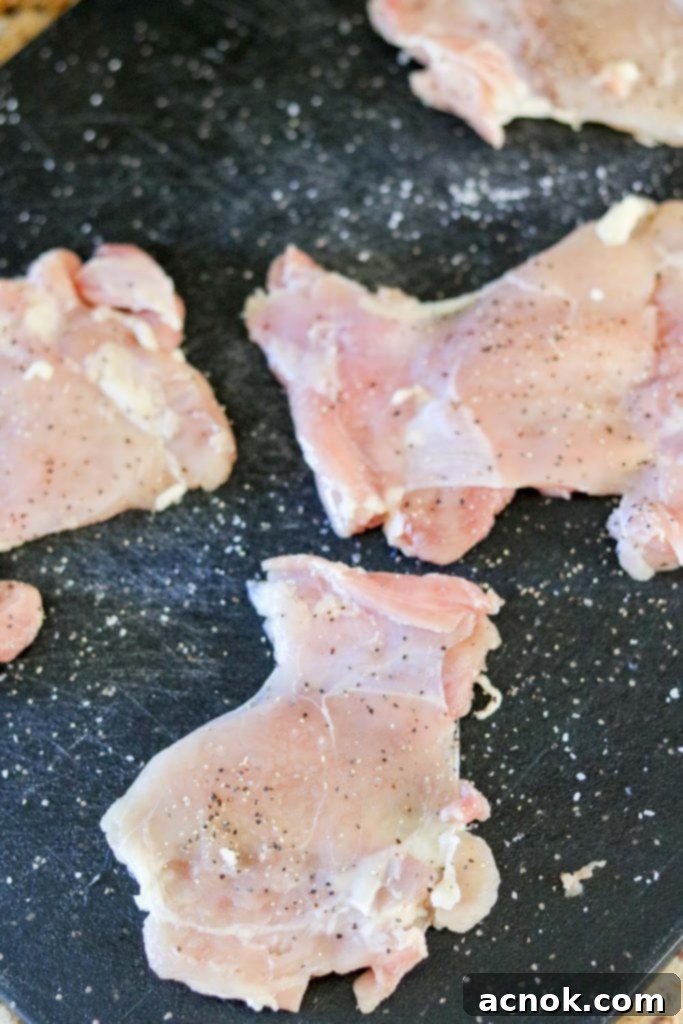 Pounded chicken thighs seasoned with salt and pepper.