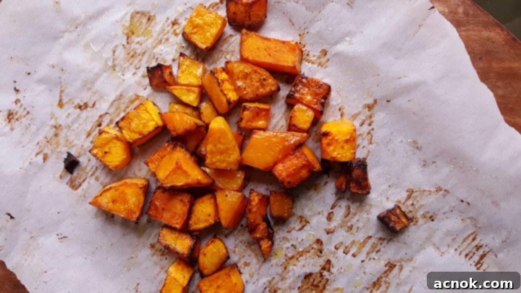 Roasted butternut squash on a rimmed baking sheet, golden brown and tender