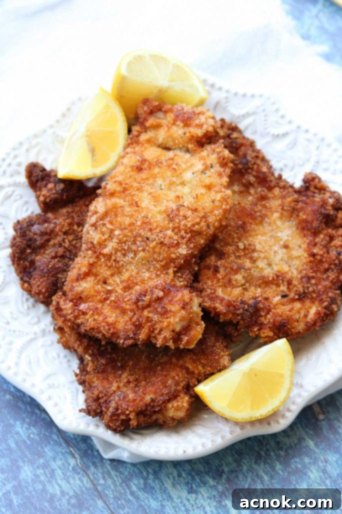 close of easy chicken schnitzel with lemon wedges 