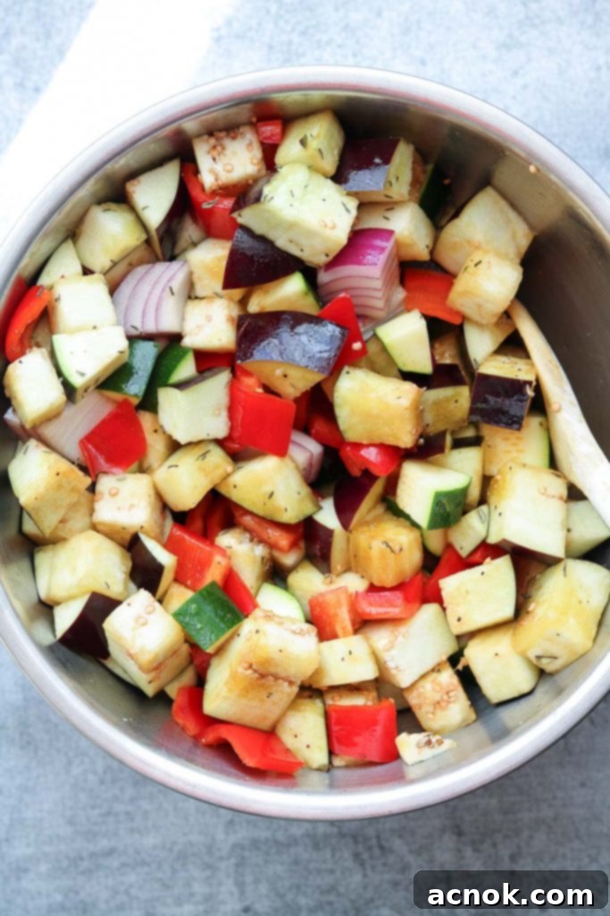 The vegetables are thoroughly tossed with the balsamic dressing, ready for roasting.