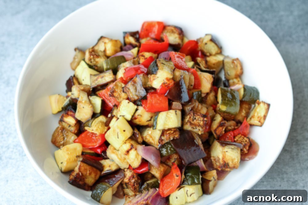 Horizontal photo of a vibrant mix of roasted vegetables, perfectly cooked and lightly charred.