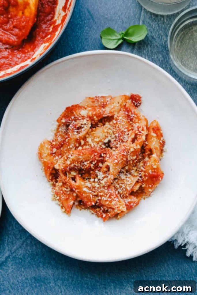 A bowl of Tomato Butter Sauce Pasta with Garlic Breadcrumbs, served with a glass of wine, ready for a delicious meal.