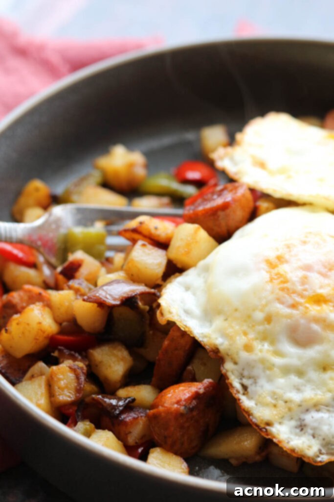 cajun spiced potato hash with sausage with two eggs over medium in plate