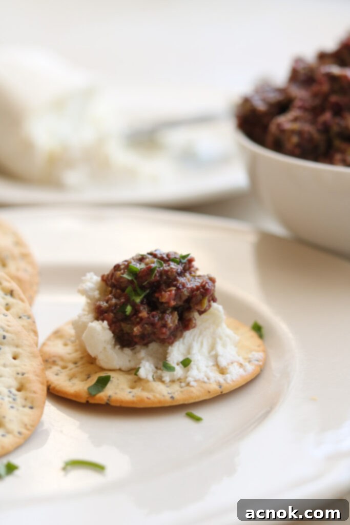 mixed olive tapenade on water  cracker with goat cheese 