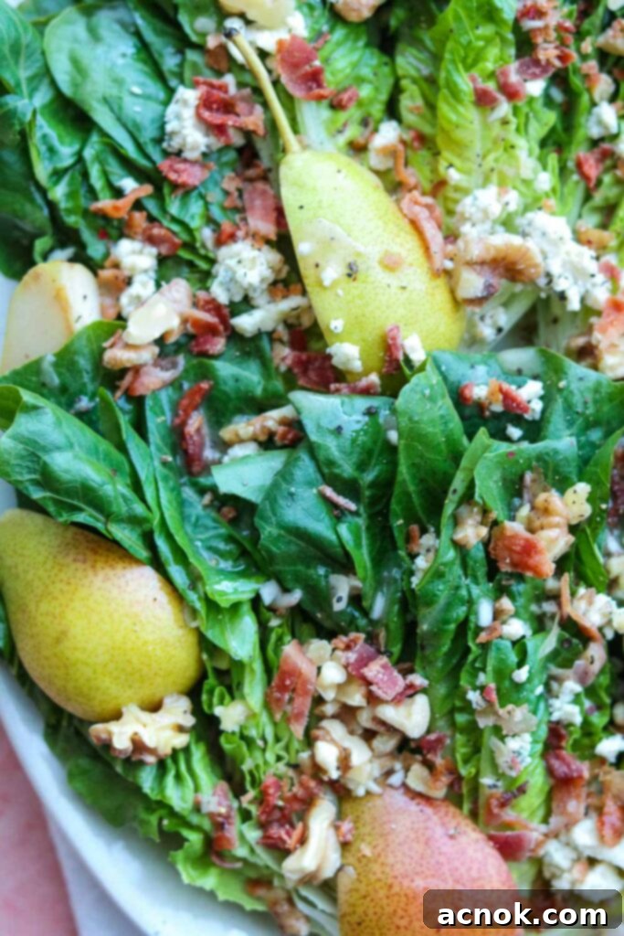 closeup of little gem pear and gorgonzola salad with bacon bits and dressing 