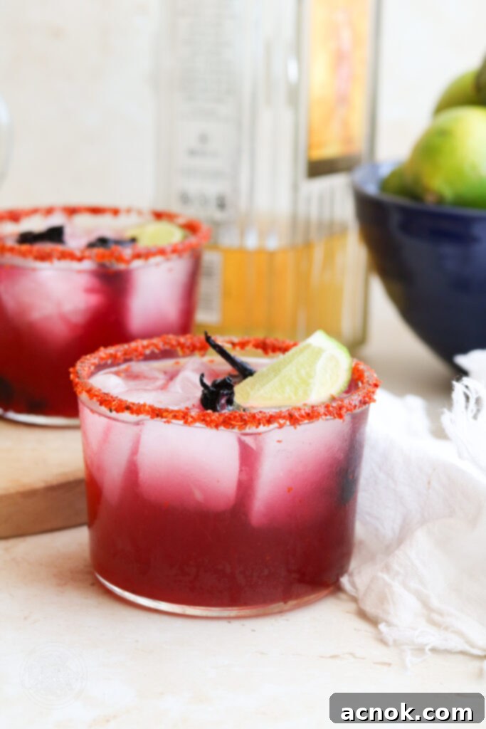 hibiscus tequila cocktail with Centennario and limes in background