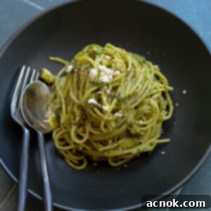kale pistachio feta pesto on spaghetti in black bowl