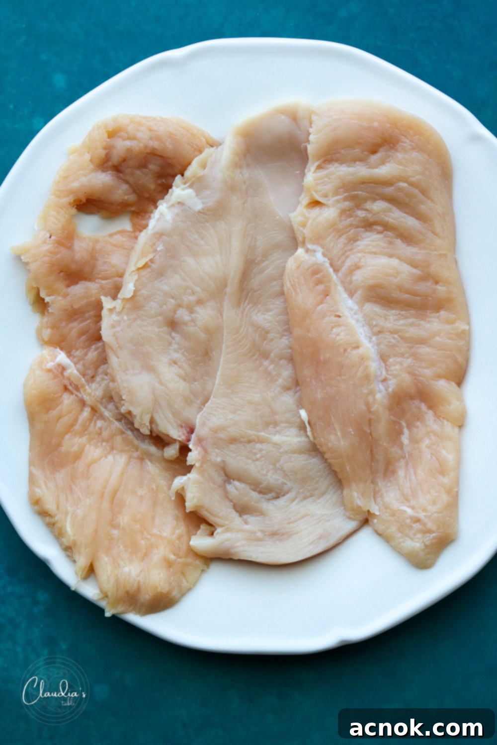 Pounded chicken breast, cut in half, ready for stuffing.