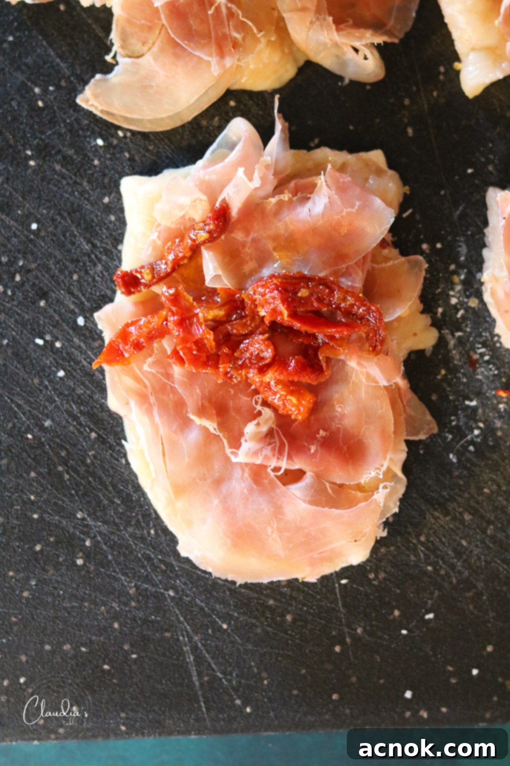 Julienned sun-dried tomatoes in oil added on top of prosciutto and chicken.