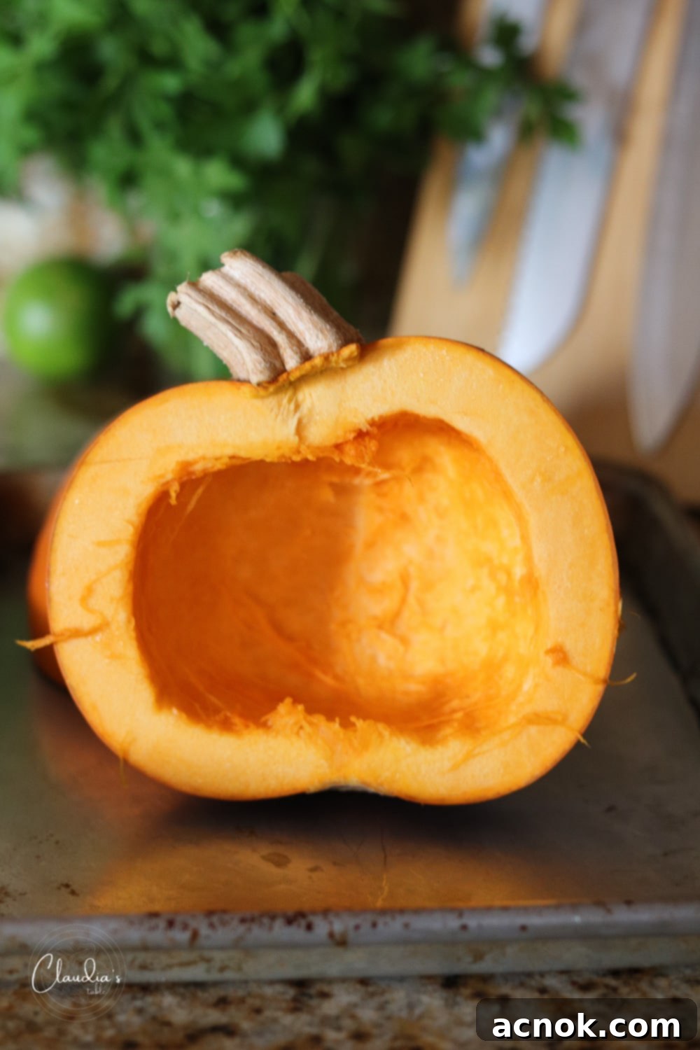 Pumpkin halves with seeds and fibrous membrane removed, showing clean cavities, ready for roasting.
