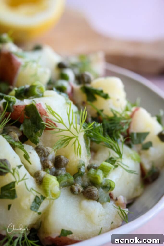 Close-up of lemon caper potato salad, showing the texture of the potatoes and dressing