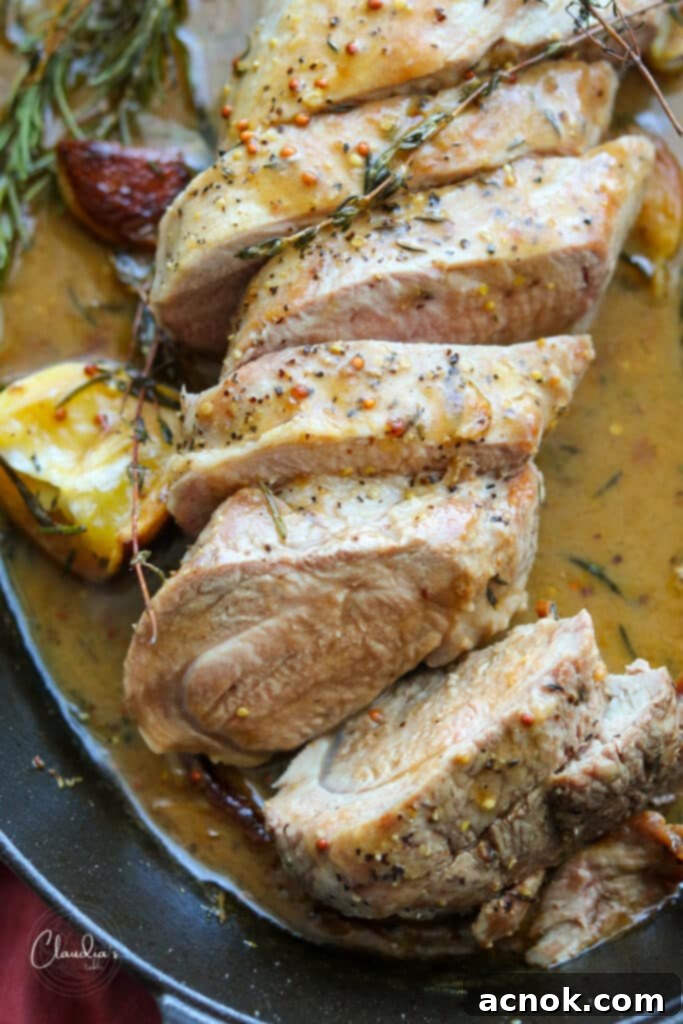 Pork tenderloin with lemon herb pan sauce in cast iron pan, ready to serve