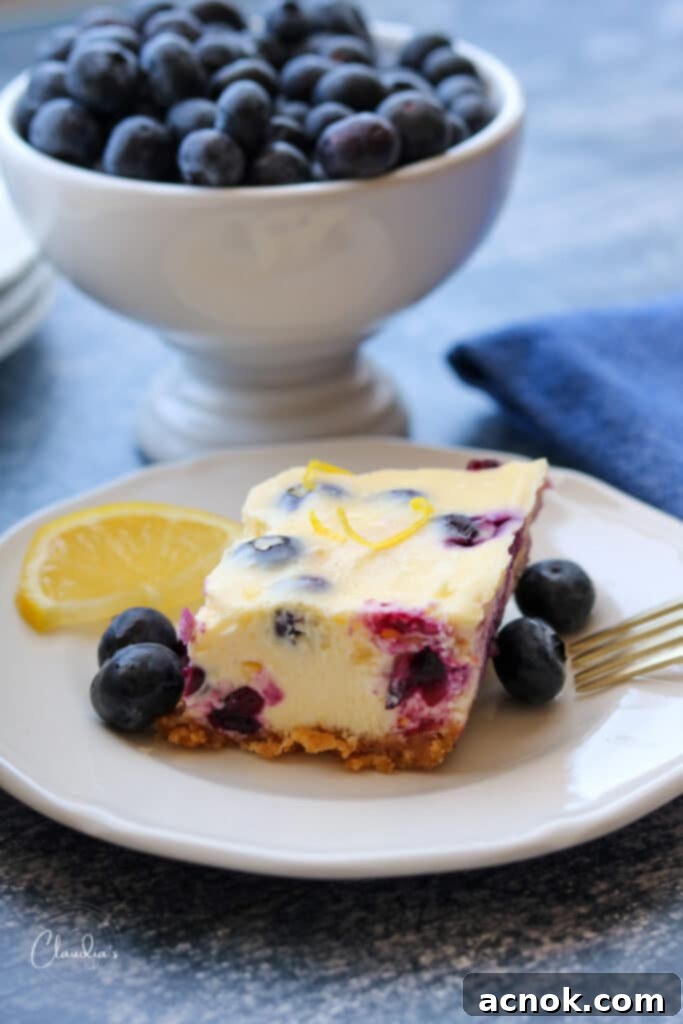 blueberry and lemon cheesecake bar on plate with blueberries