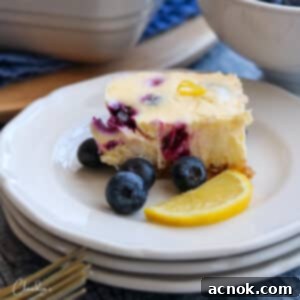 blueberry lemon cheesecake bar with fresh blueberries on white plate