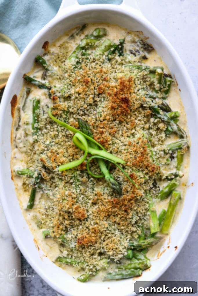 baked asparagus with gruyere in white baking dish 